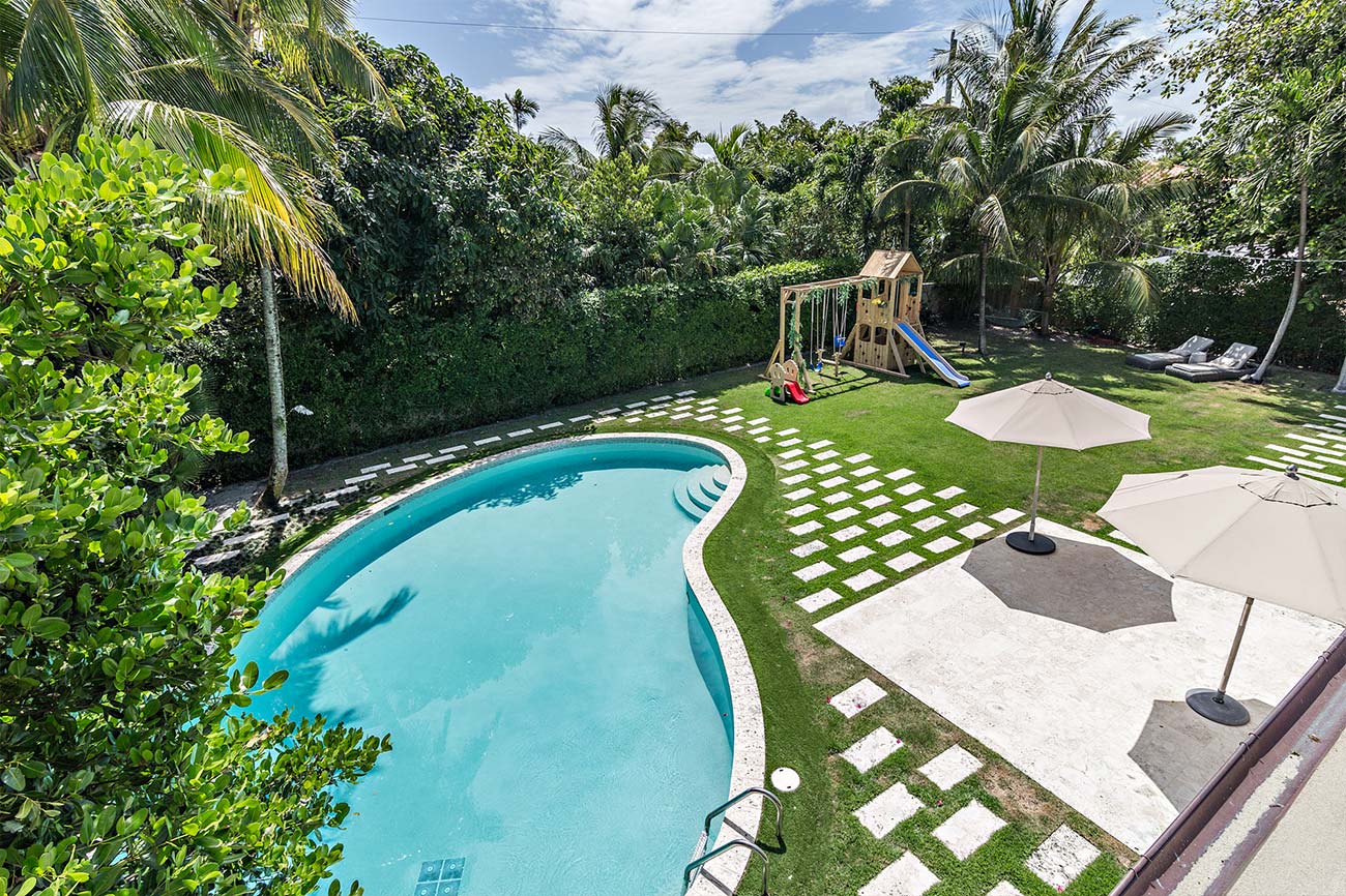 elevation view of backyard with playground and pool